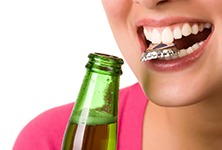 Woman with bottlecap between teeth headed for dental emergency in Greensboro 