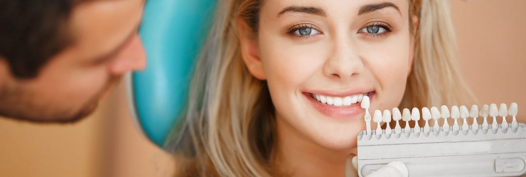 veneer shade chart in front of woman's smile