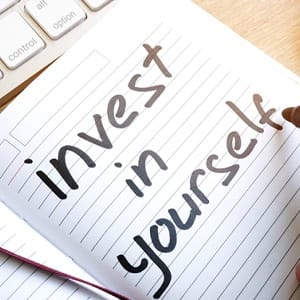 a notebook with a page that says “invest in yourself”