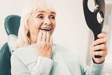 Woman admiring her new dental implants in Greensboro