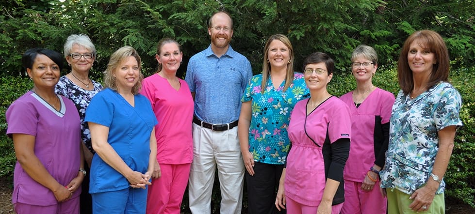 Greensboro dentist and dental team members smiling outdoors