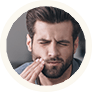 man with beard holding cheek in pain