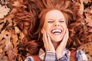 woman smiling autumn leaves