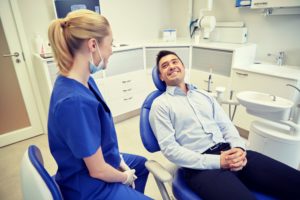 man in dress shirt smiling at dentist in Greensboro