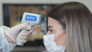 Greensboro dentist giving no-touch temperature check to patient in COVID-19