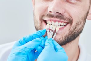 dentist using a shade guide to select the perfect dental crown color