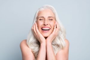 Woman with long white hair closing her eyes and smiling wide