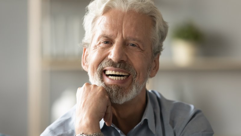 An older man smiling with his new dental implants