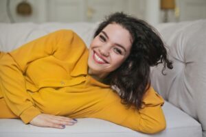 Smiling woman laying on a white couch