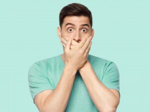 Man covering his mouth due to a loose dental implant 