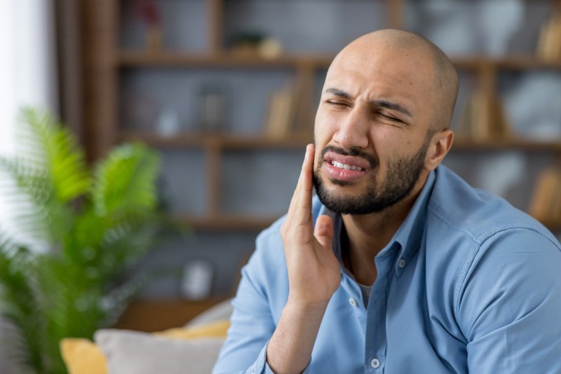 A grimacing man whose jaw only hurts on one side