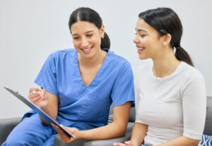 Patient and dental team member looking at document on clipboard